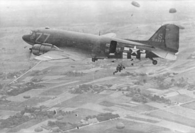 Springende_Amerikaanse_parachutisten_vanuit_een_Dacota_boven_Groesbeek_17_september_1944.-1